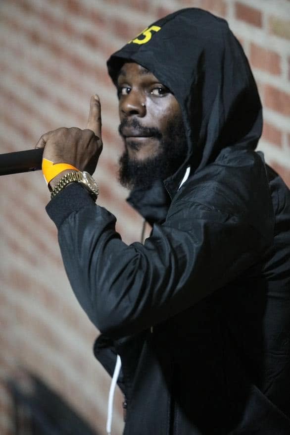 Aboog Carter performing in a black hooded jacket